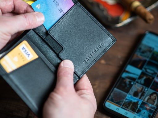 black leather bifold wallet on persons hand