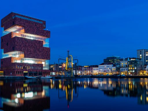 brown concrete building near body of water during night time