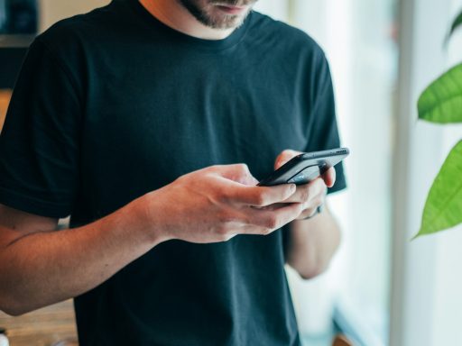 man in black crew-neck top using smartphone