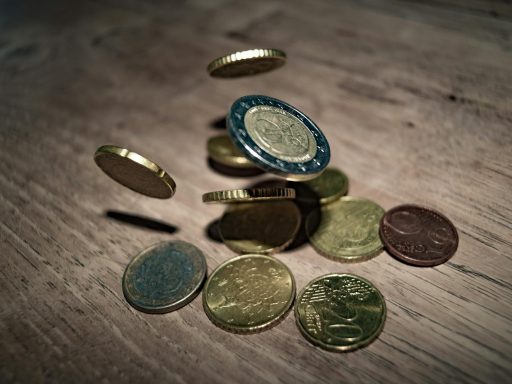 Capture of euro coins falling and spinning on a wooden table. Perfect depiction of finance and currency."
