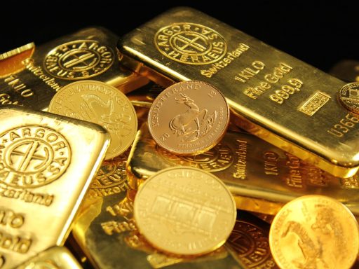 Gouden beleggingsmunten en een goudstaaf op een houten ondergrond