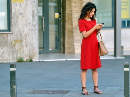 Een jonge persoon kijkt bezorgd naar een smartphone met financiële grafieken