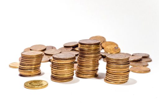 Goudstaven en gouden munten naast elkaar op een tafel