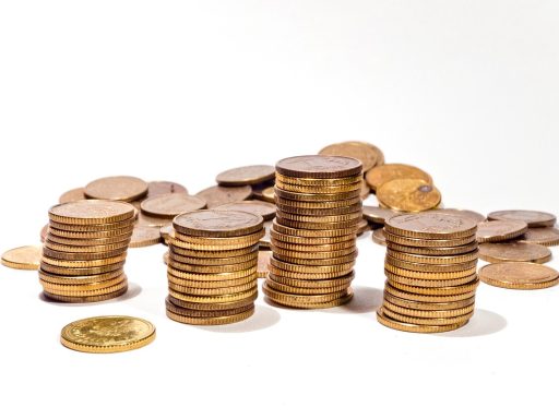 Goudstaven en gouden munten naast elkaar op een tafel